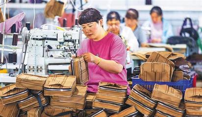 阜平縣顧家臺村九歌皮具有限公司,村民在加工箱包。當(dāng)?shù)厣a(chǎn)的箱包通過線上線下俏銷全國各地。